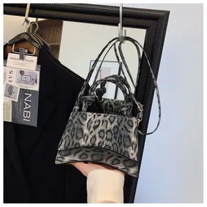 Detail of leopard print faux fur handbag with round handle and curved base design