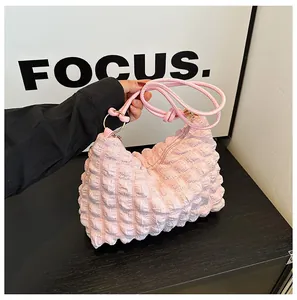 Detail of light pink popcorn texture fabric on this stylish ruched cloud underarm bag