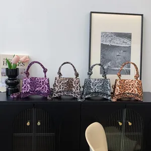 Elegant leopard print hourglass handbags in purple, black, and brown with top handles