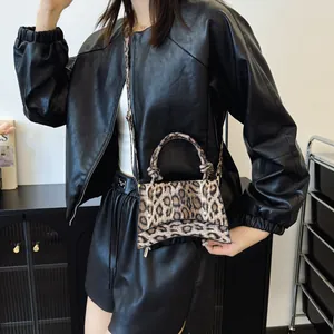 Chic leopard print hourglass handbag with knotted handle and shoulder strap on model