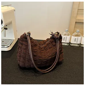 Detail of coffee brown pleated tote bag with 3D texture and long leather handles