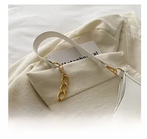 Close-up of a white leather dumpling bag featuring a gold chain strap and metal hardware