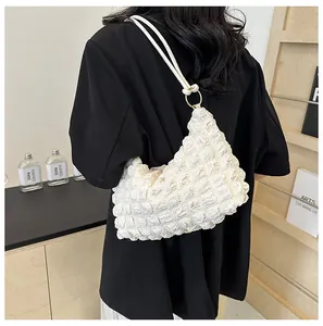 Detail view of white popcorn texture shoulder bag with gold ring hardware and thin strap