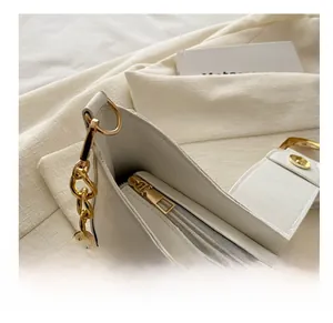 Detail shot of smooth golden zipper and light gray lining inside the white dumpling bag
