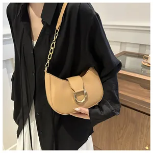 Detail view of khaki leather crescent bag featuring a golden D-ring buckle and chunky chain