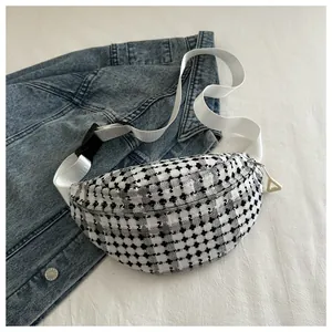 Close-up of black and white plaid tweed waist bag featuring white nylon strap and buckle