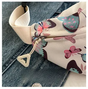 Détail de la fermeture éclair en nylon blanc et du curseur en argent sur le sac papillon
