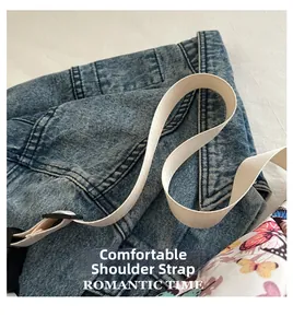 Détail de la bandoulière réglable et imprimé papillon sur sac en denim bleu