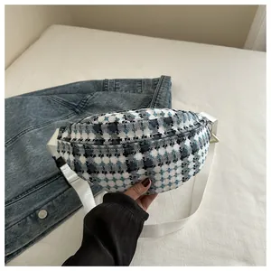 Macro shot of checkered tweed belt bag featuring blue, white, and black woven texture
