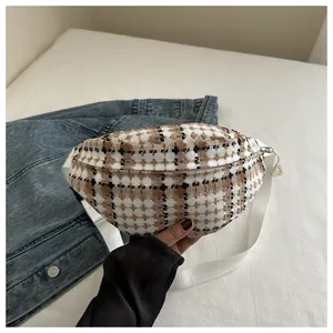 Close-up of vintage plaid fanny pack with white adjustable strap and moon shape