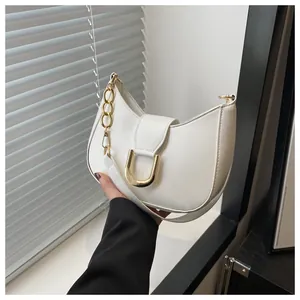 Detail of white leather hobo bag featuring gold U-shaped buckle and chunky chain strap