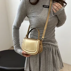 Elegante borsa a sella dorata con finitura metallica e tracolla regolabile donna