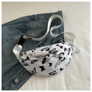 Dettaglio marsupio in tela bianca con stampe di farfalle nere su fondo giacca di jeans