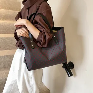 Large grey tote bag with red heart pattern and sturdy black shoulder straps