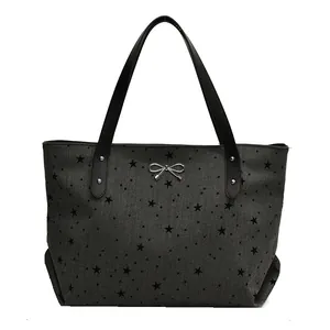 Large star print canvas tote bag with silver bow detail and black leather handles