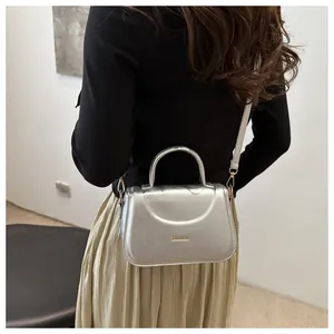 Borsa a tracolla argento con scritta FASHION indossata da una modella vista di lato