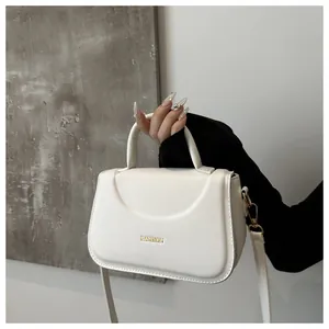 Dettaglio borsa a mano bianca con logo dorato fashion e fibbie metalliche molto eleganti