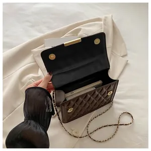 Inside view of brown quilted patent leather crossbody bag with chain strap and phone