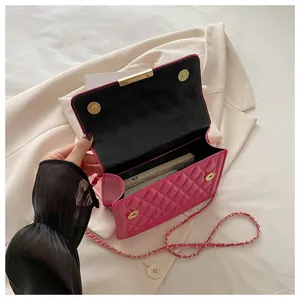 Top view of fuchsia quilted crossbody bag showing interior capacity with a smartphone