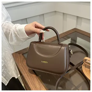 Dettaglio borsa marrone in pelle PU con logo FASHION dorato e manico superiore fisso