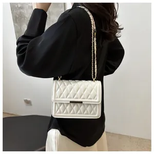 Detailed view of cream quilted crossbody bag with gold metal chain and leather strap