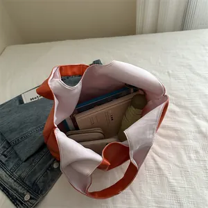 Large orange oil wax leather tote bag showing spacious interior with daily essentials