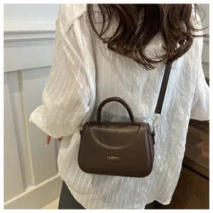 Borsa a tracolla in pelle marrone su modella per mostrare dimensioni e stile alla moda