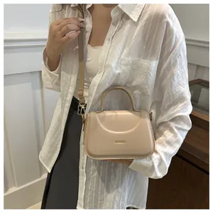 Dettaglio della borsa beige in ecopelle con scritta dorata e manico arrotondato