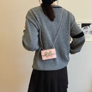 Pink mini crossbody bag with silver bow decoration and metal chain strap for women