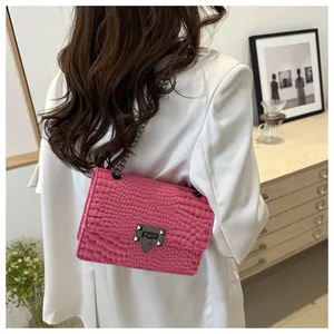 Vue arrière d'un mannequin portant un sac rose croco avec un blazer blanc