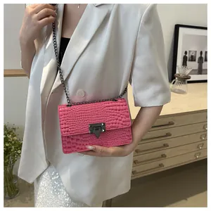 Détail du sac rose à texture crocodile avec fermoir métallique et bandoulière