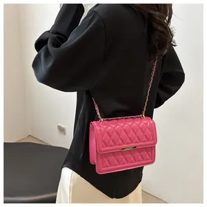 Macro shot of pink quilted crossbody bag showing gold chain strap and detailed texture