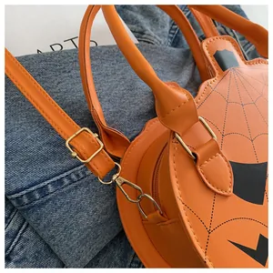 Detailed macro view of pumpkin-shaped crossbody bag with orange PU leather and spider web pattern