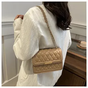 Detailed view of khaki quilted crossbody bag with gold chain strap and metal trim