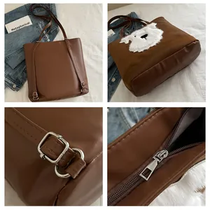 Close-up detail of the brown tote bag with white plush dog patch and metal buckles