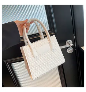 Détail du sac à main blanc matelassé avec motif goutte et poignées robustes