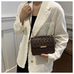 Detailed view of the dark brown quilted crossbody bag featuring elegant gold metal trim