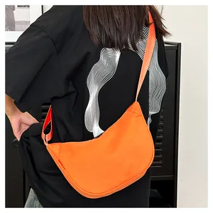 Detail shot of a vibrant orange waterproof crescent moon bag worn across the shoulder