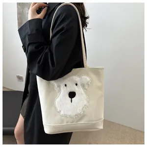 Detail of a beige tote bag featuring a fluffy white schnauzer plush patch and canvas texture