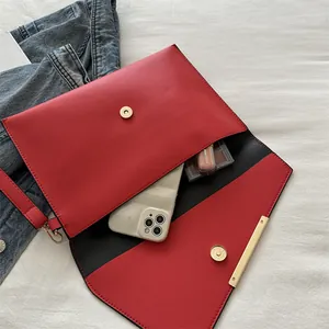 Modern red envelope clutch bag with gold metal trim and detachable wrist strap