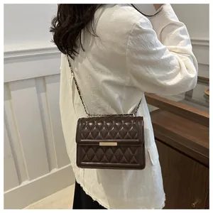 Detailed close-up of brown quilted faux leather texture and gold chain on small crossbody bag