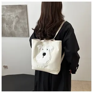 Close-up of white tote backpack with a cute plush dog head patch and black contrast straps