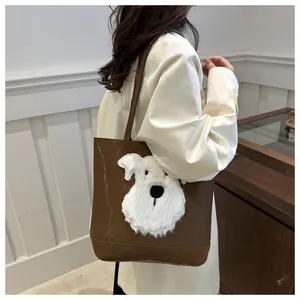Detail of a brown PU leather tote bag featuring a cute 3D plush puppy design decoration