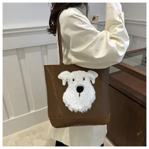 Detail of a brown tote bag featuring a fluffy white plush dog patch and thin shoulder strap
