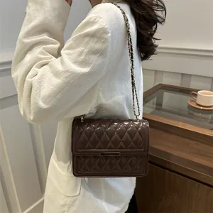 Dark brown quilted crossbody bag with gold chain strap and metallic lock for women