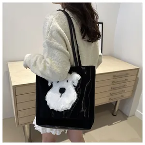 Large black tote bag with white plush dog patch embroidery shown in a daily lifestyle setting