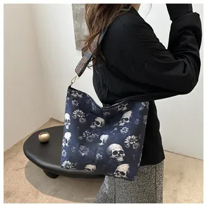Detail of gothic tote bag with skull floral print and ethnic woven shoulder strap