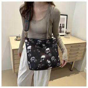 Detail of gothic skull floral tote bag with wide ethnic shoulder strap in lifestyle setting
