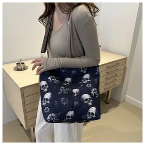Detail of navy tote bag with skull floral print and ethnic style embroidered strap