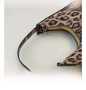 Vue détaillée de la fermeture éclair dorée et du motif léopard sur le sac chic